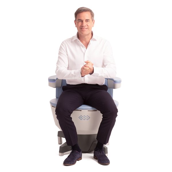 Man seated on Emsella chair, promoting pelvic floor strength and wellness, in a clinical setting.
